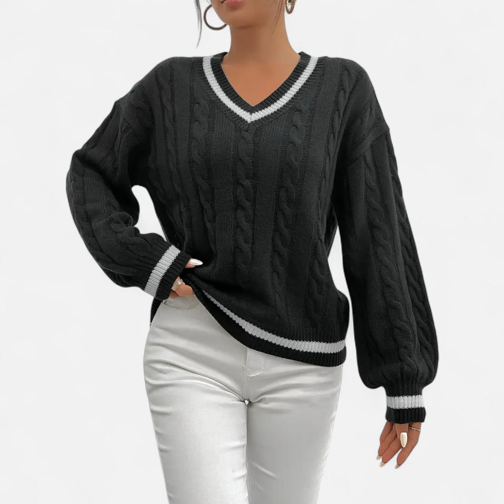 Black cable knit sweater with white trim worn by a person on a white background