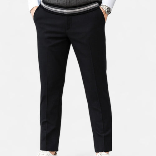 Black pants worn by a person on a white background