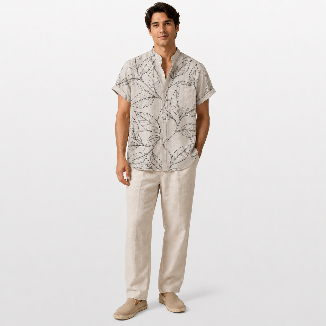 Man wearing a patterned shirt and beige pants on a white background