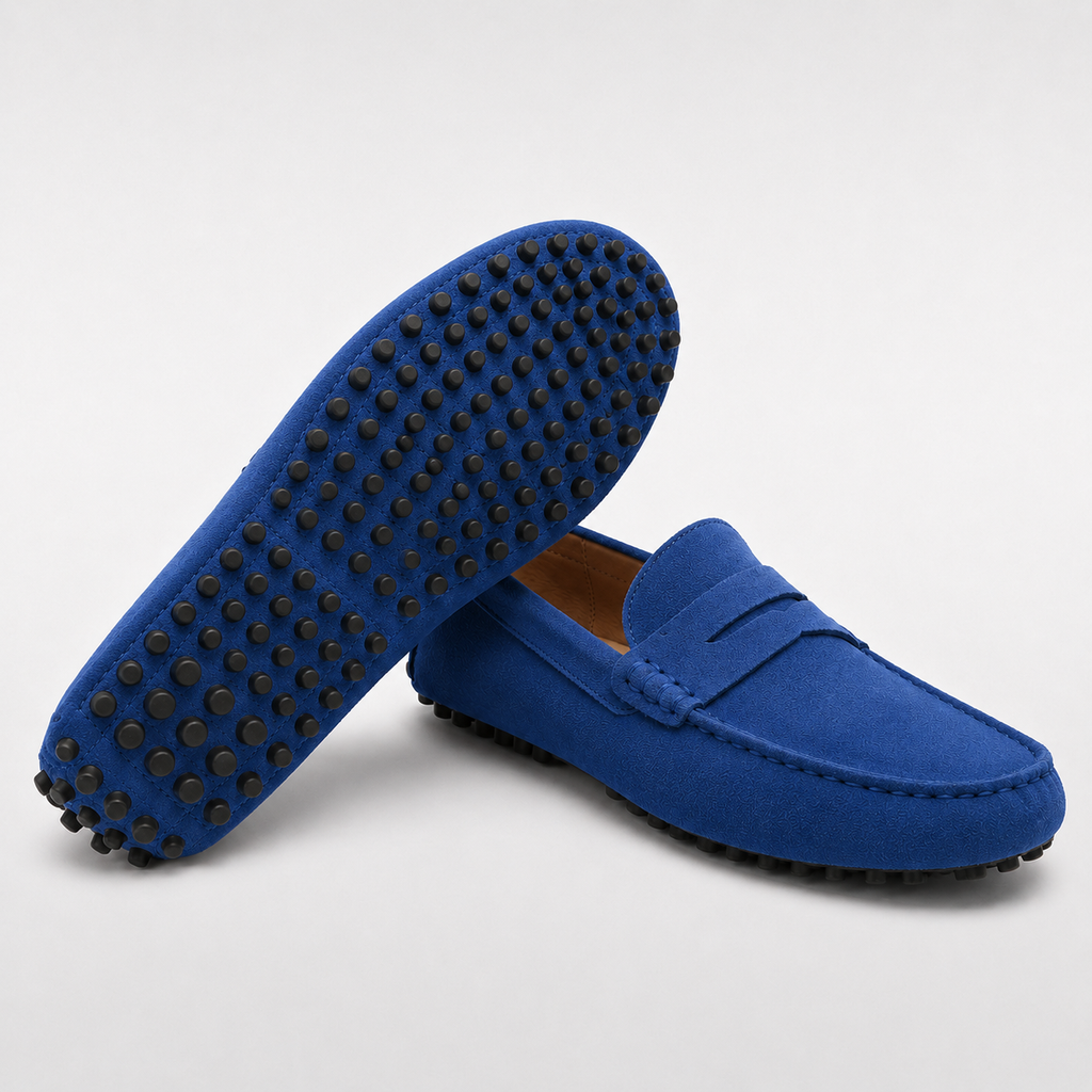 Blue loafers with black soles on a light gray background