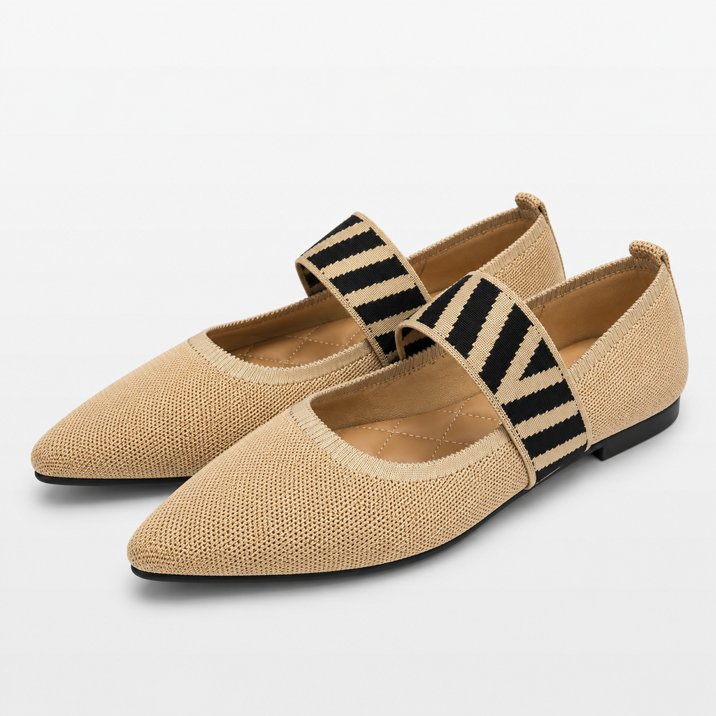 Pair of beige flat shoes with black and white striped straps on a light gray background