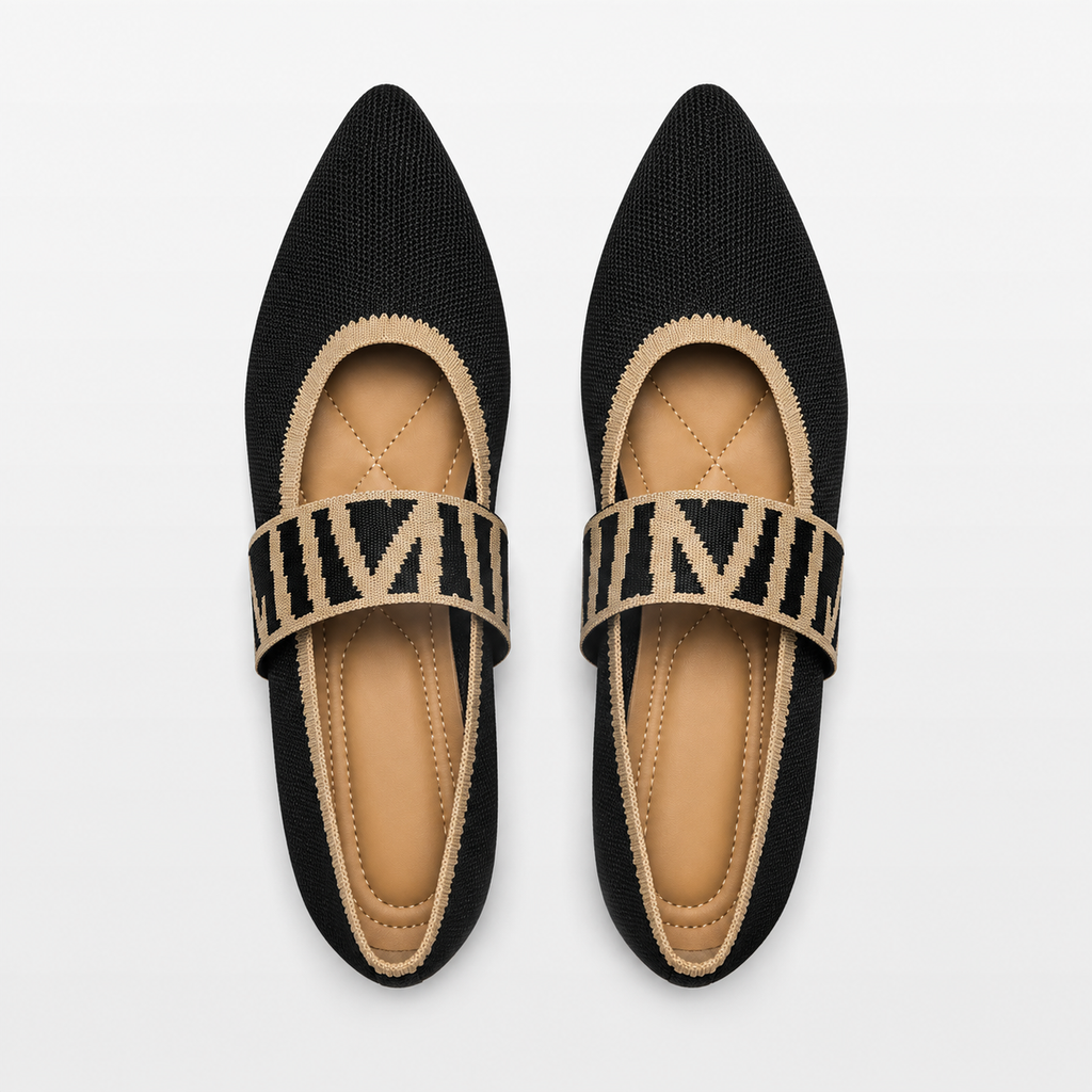 Pair of black pointed-toe flats with beige straps on a white background