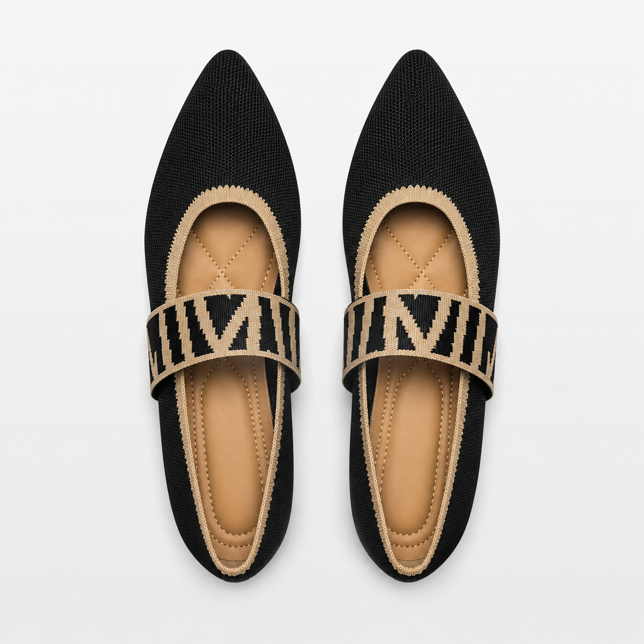 Pair of black pointed-toe flats with beige straps on a white background