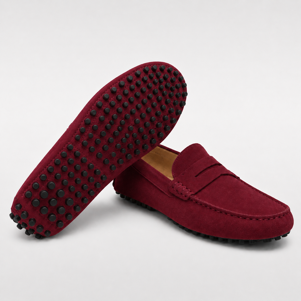 Red loafers with black tread pattern on a light gray background