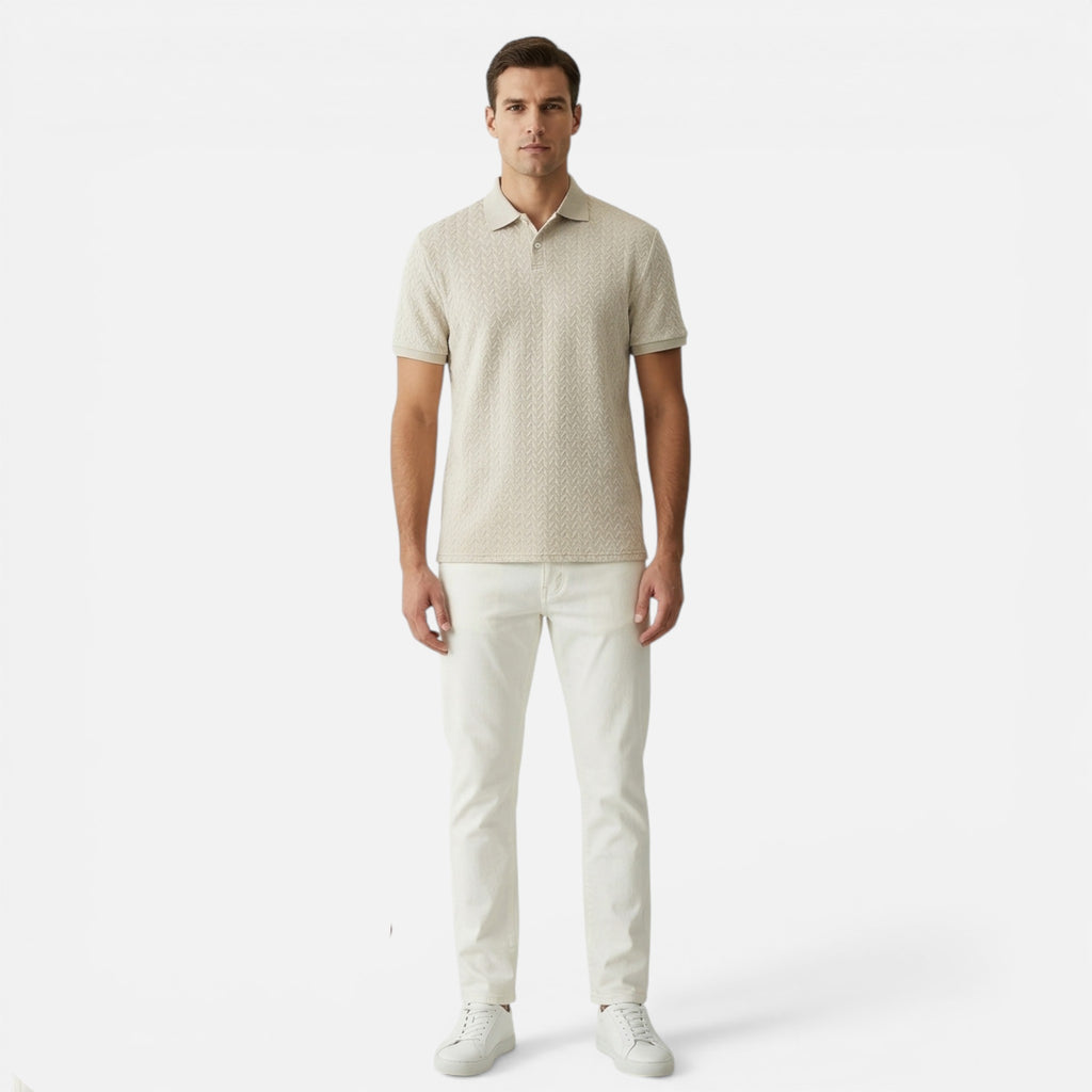 Man wearing a beige patterned polo shirt and white pants on a white background