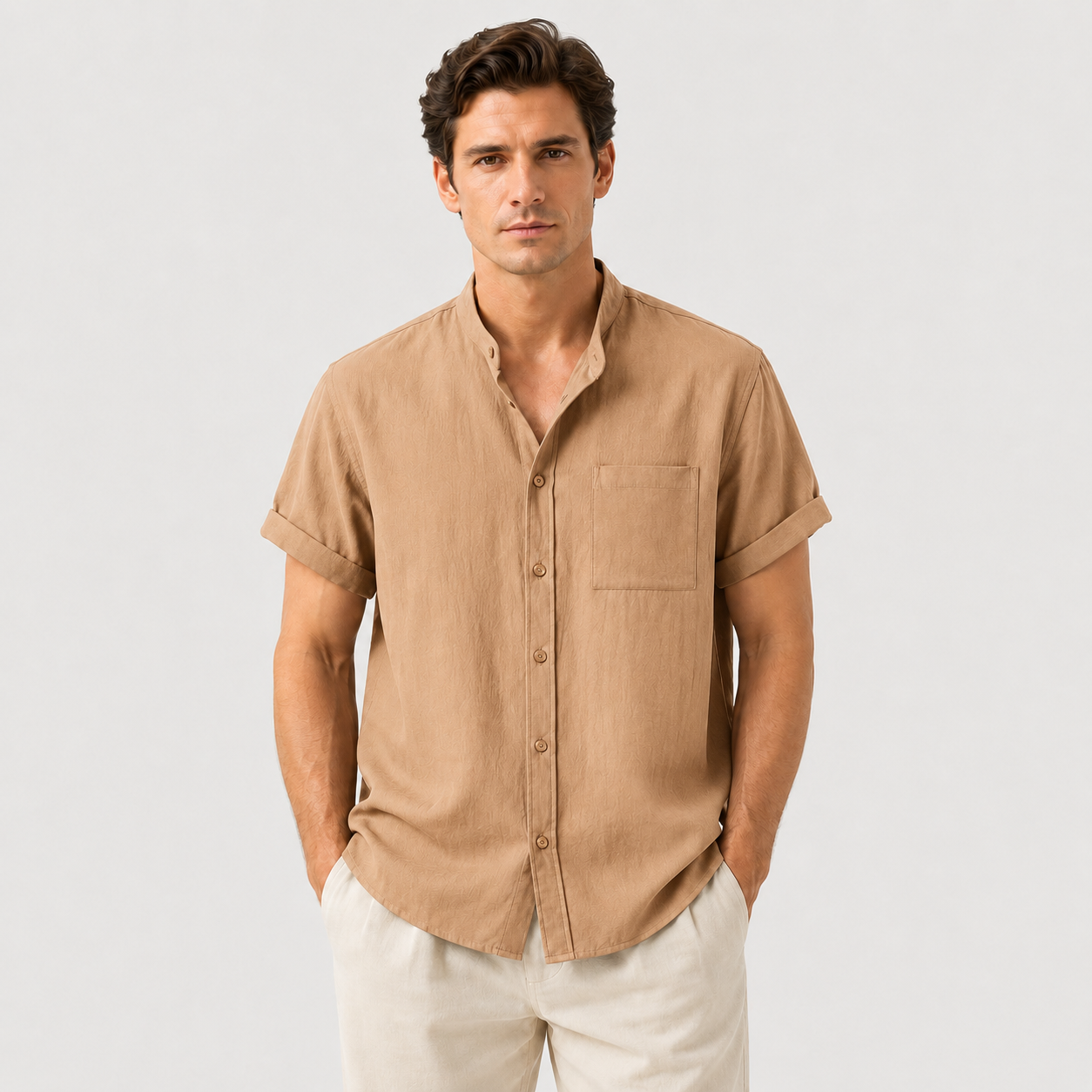 Man wearing a beige short-sleeve shirt against a light gray background