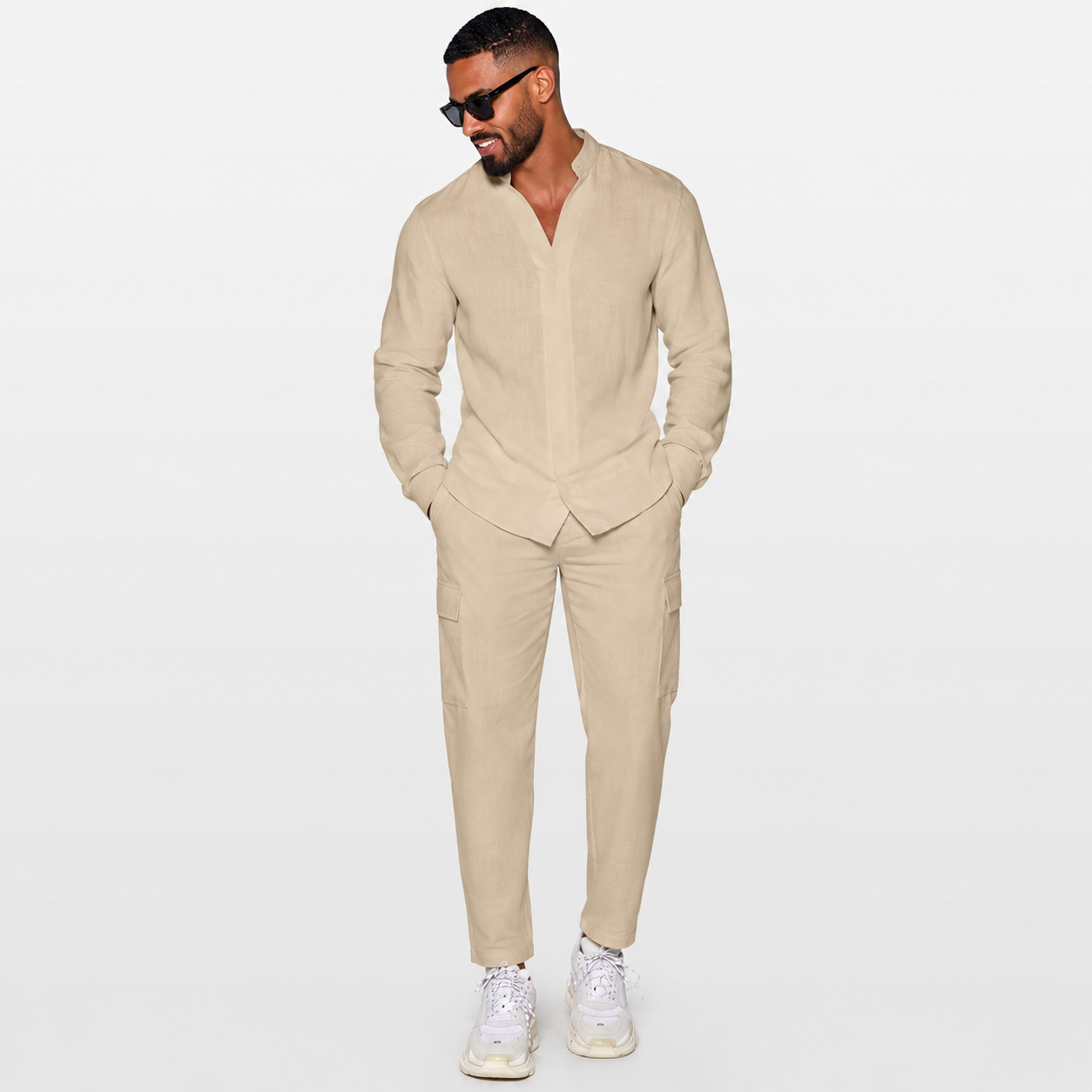 Man wearing a beige suit with white sneakers on a light gray background