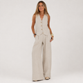 Woman wearing a beige vest and wide-leg pants on a white background