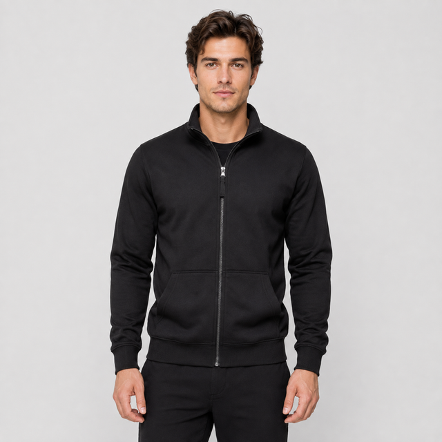 A man wearing a black zip-up athletic jacket with a stand collar and front pockets, photographed against a light gray studio background.