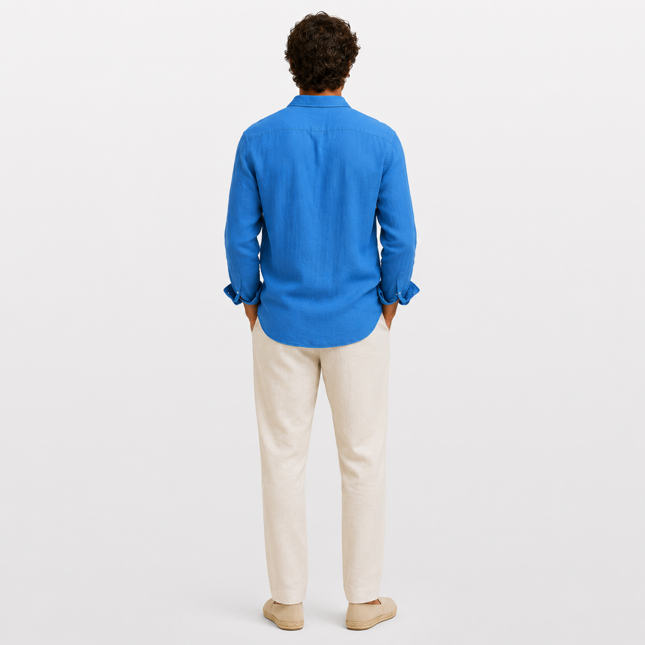 Person wearing a blue shirt and beige pants on a white background