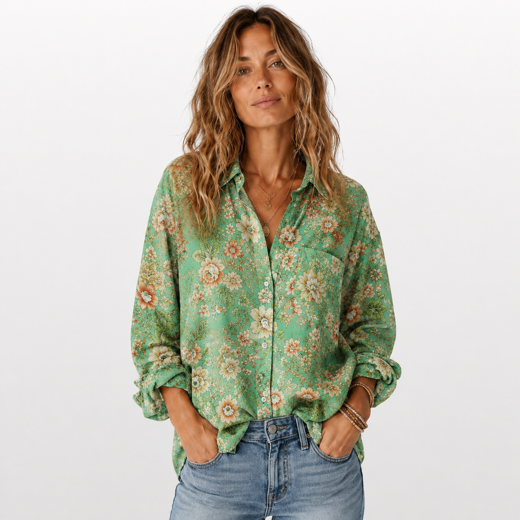 Woman wearing a green floral blouse and blue jeans on a white background