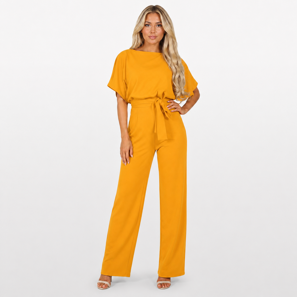 Woman wearing a mustard yellow jumpsuit on a white background
