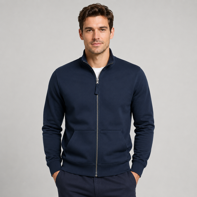 A man wearing a navy blue zip-up fleece jacket with a stand collar and front pockets, paired with matching navy pants, photographed against a neutral light gray studio background.