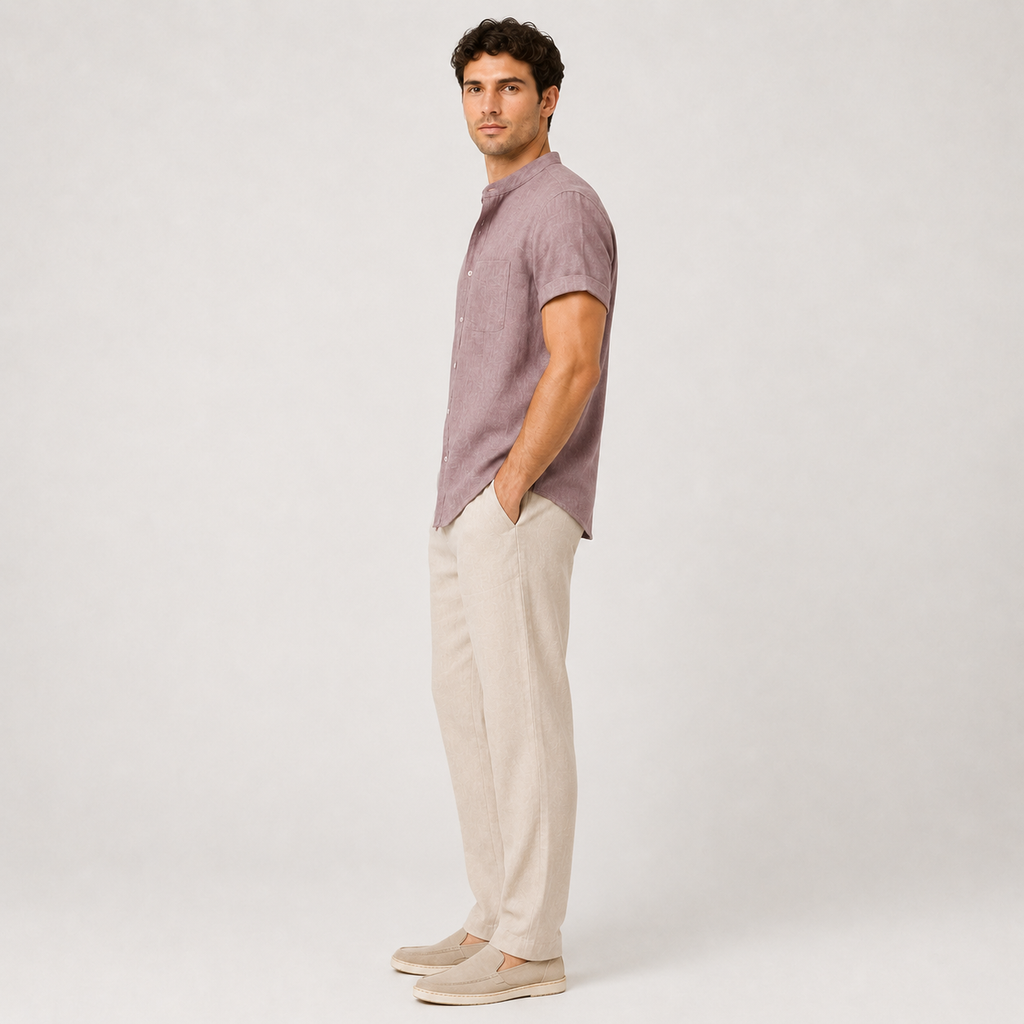Man wearing a purple shirt and beige pants against a white background