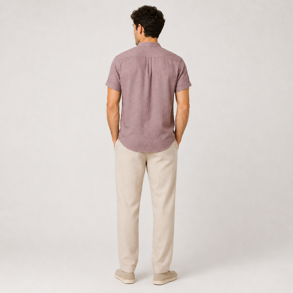 Man wearing a short-sleeve button-up shirt and beige pants on a white background