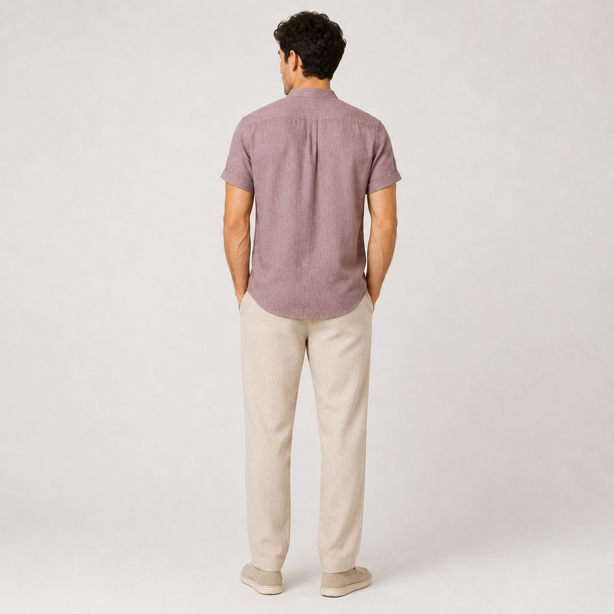 Man wearing a short-sleeve button-up shirt and beige pants on a white background