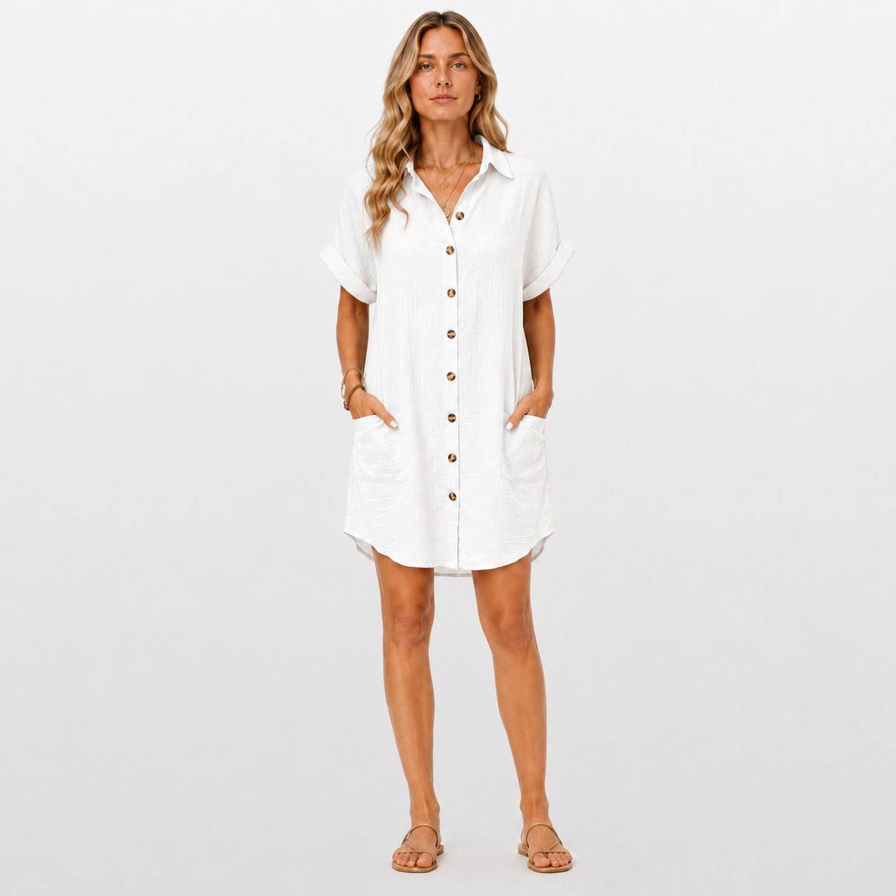 Woman wearing a white button-up dress on a plain background