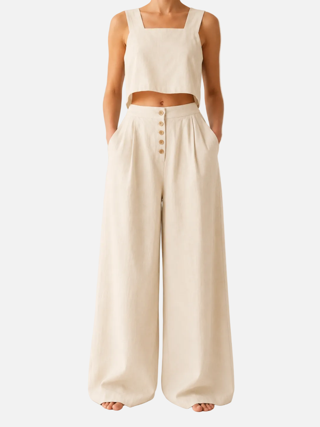 Person wearing a white sleeveless top and wide-leg pants on a plain background