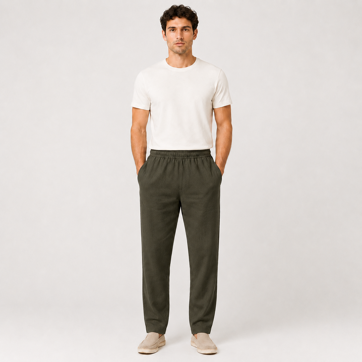 Man wearing a white t-shirt and green pants on a plain background
