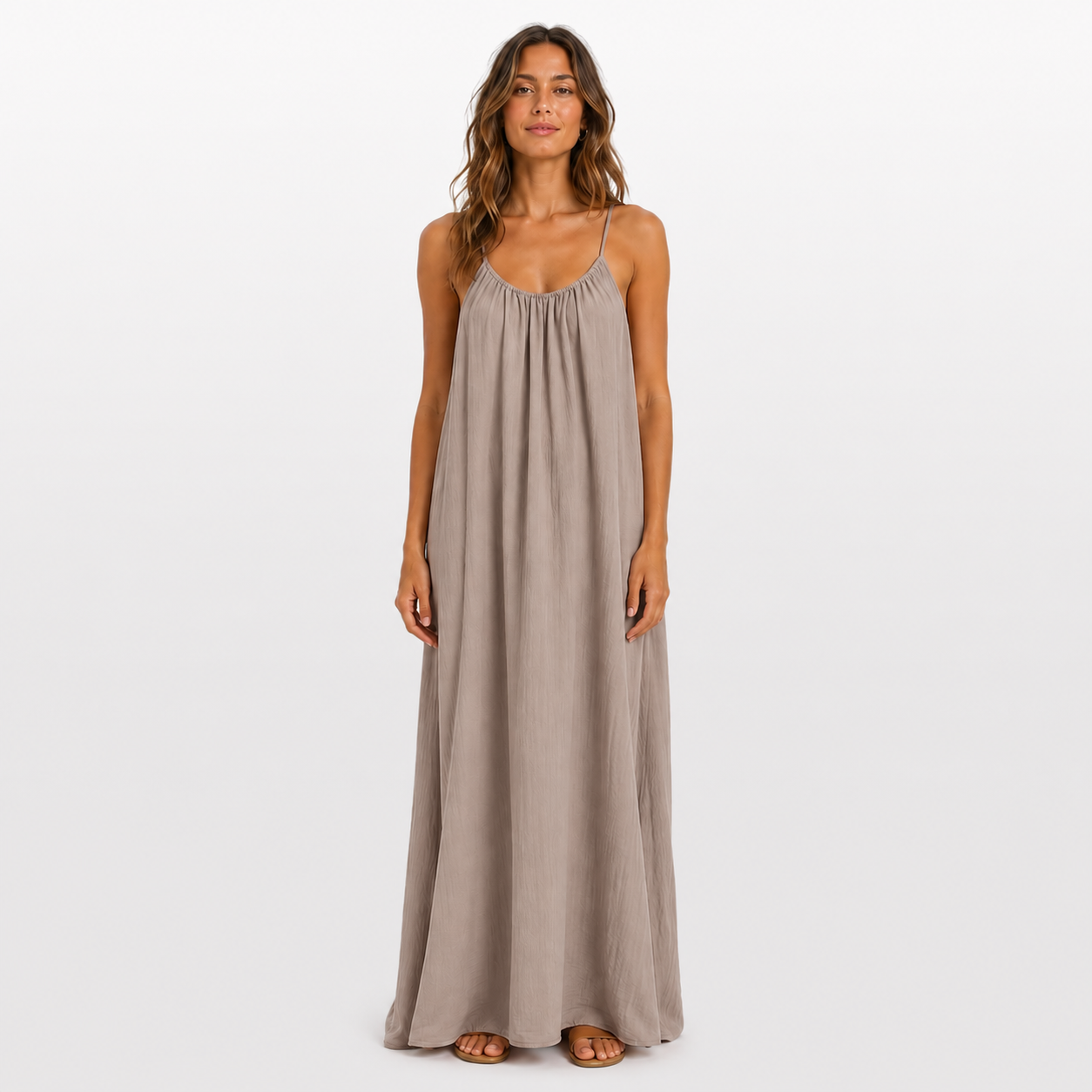 Woman wearing a long beige dress on a white background