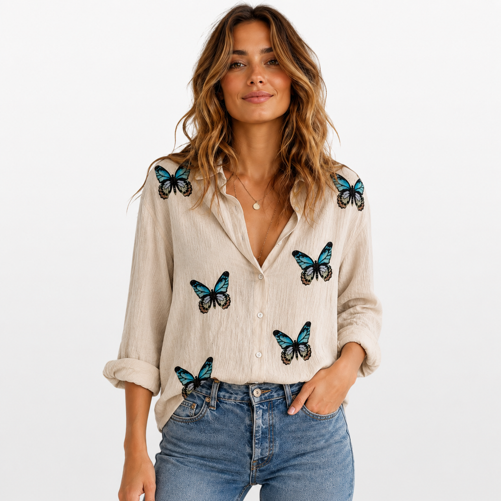 Woman wearing a beige shirt with butterfly designs on a white background