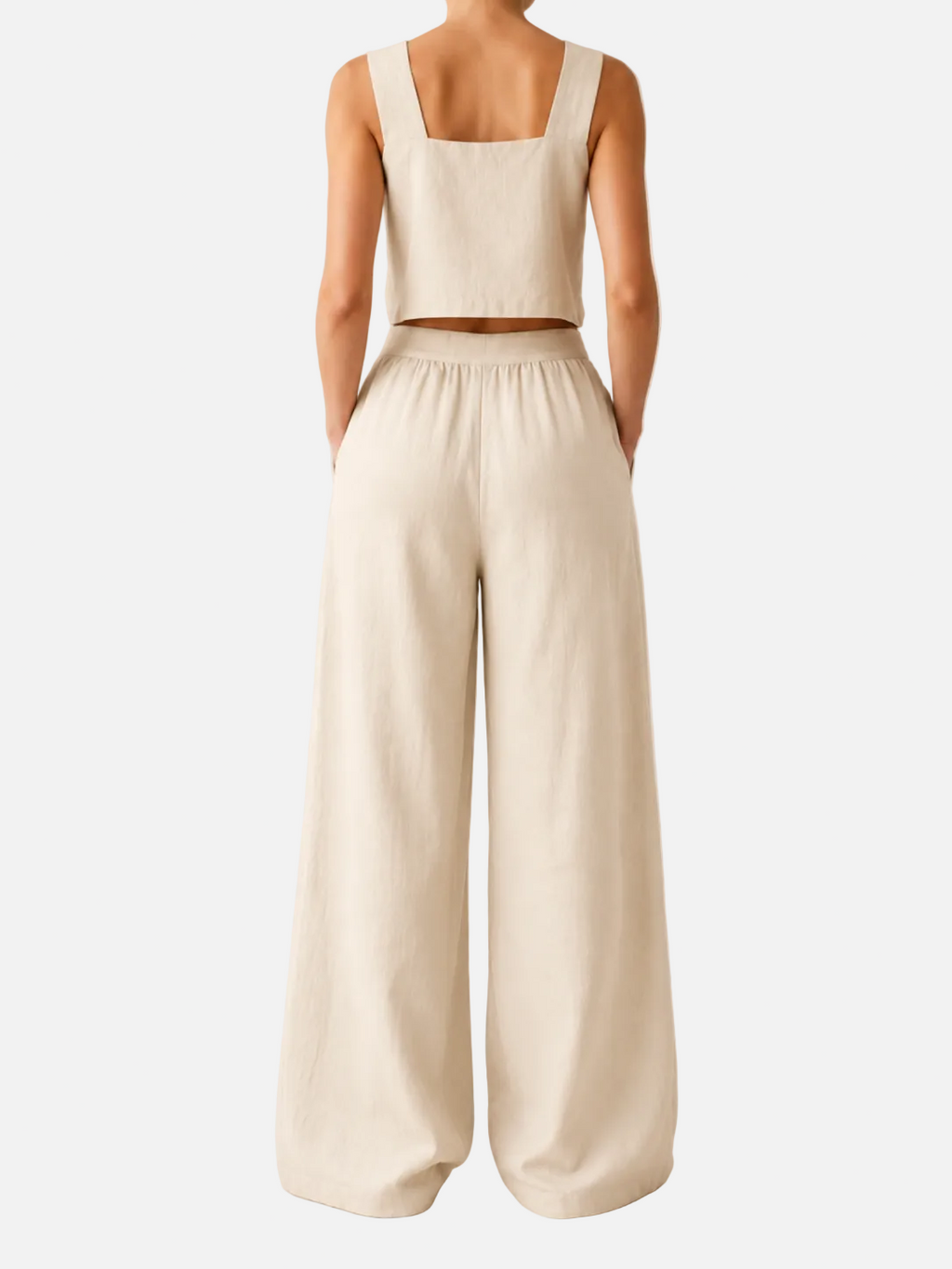 Person wearing a beige sleeveless top and wide-leg pants on a plain background