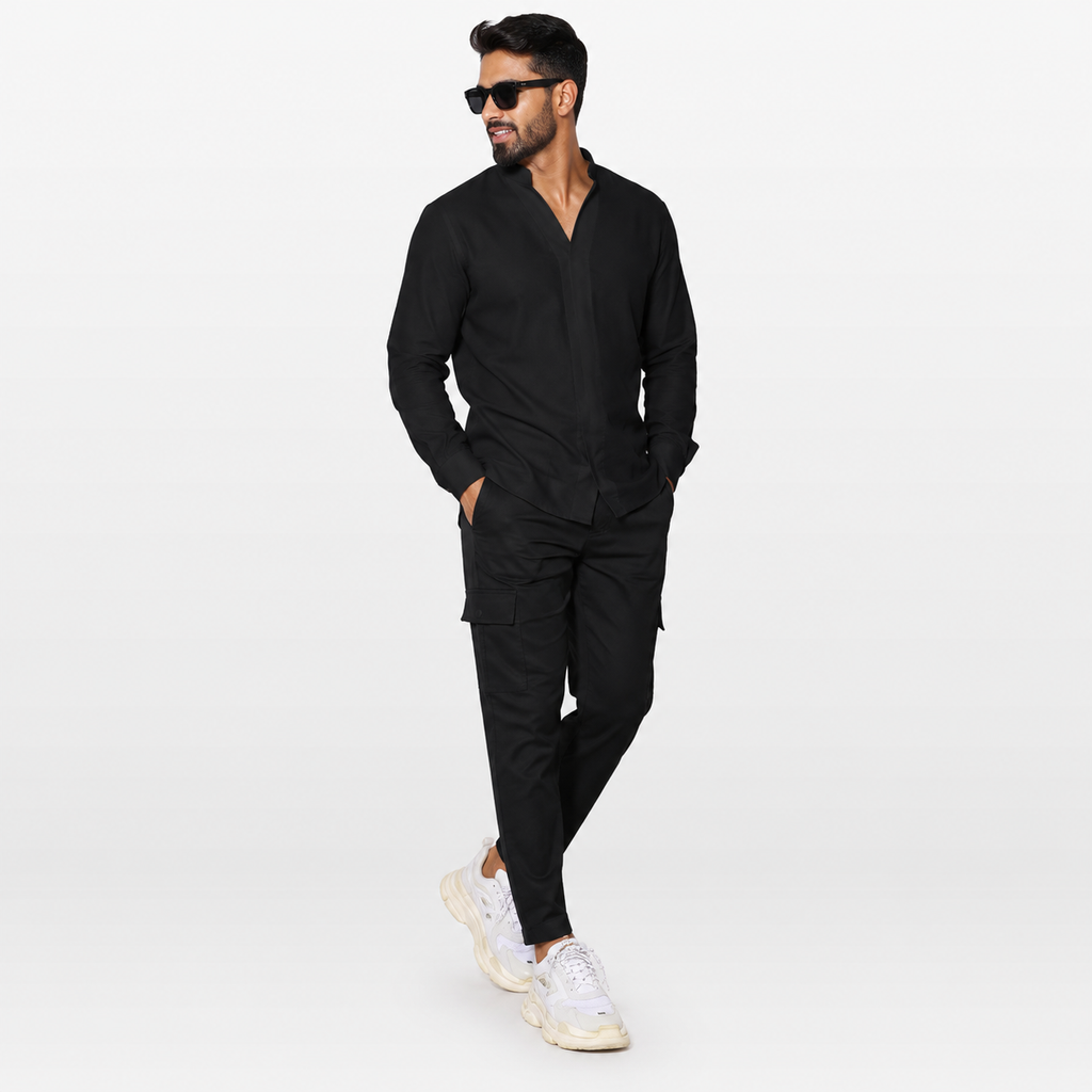 Man wearing a black outfit with sunglasses on a white background