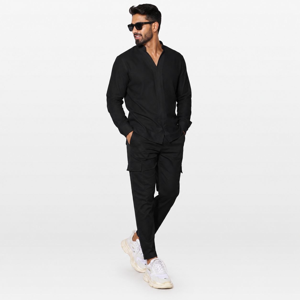 Man wearing a black outfit with sunglasses on a white background