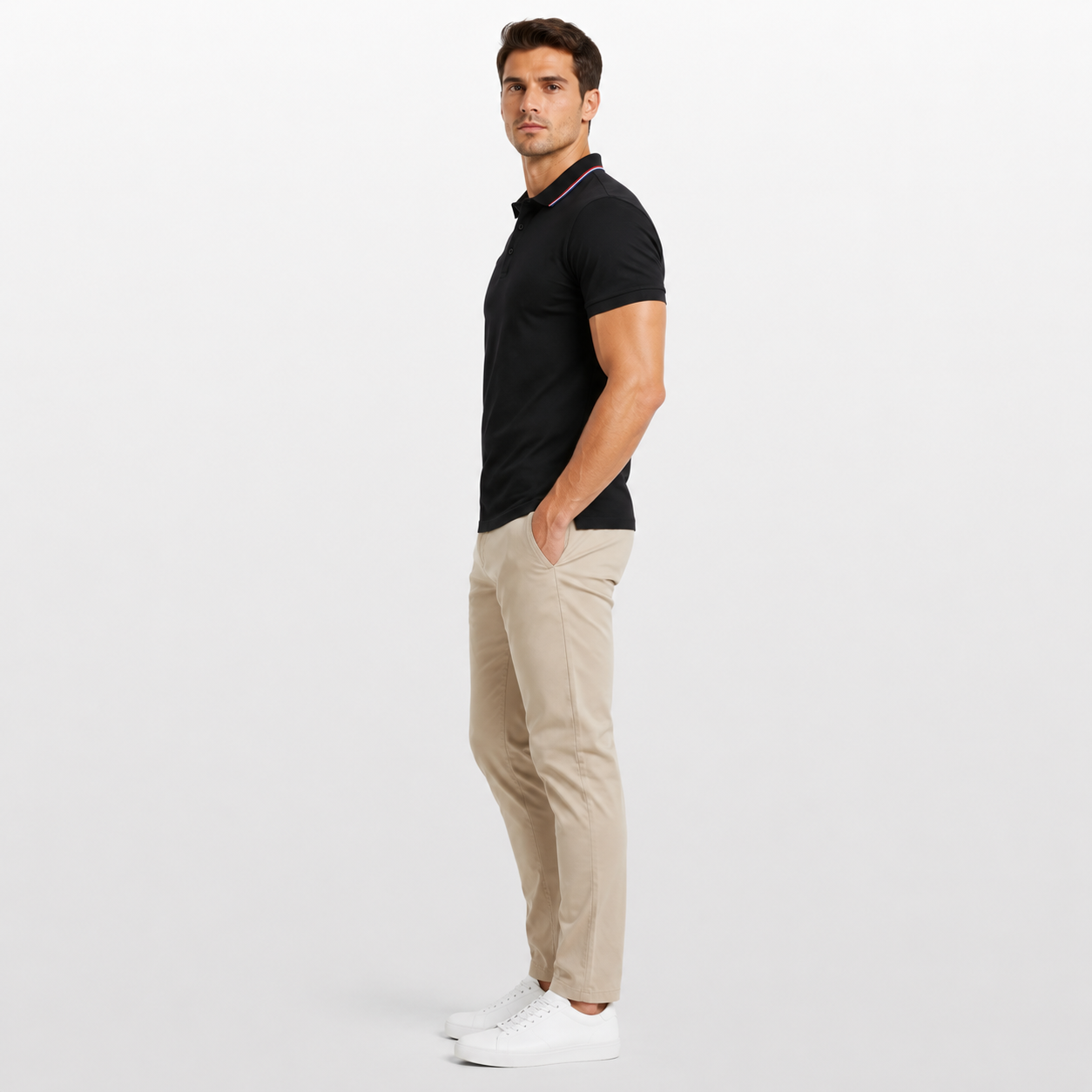 Man wearing a black polo shirt and beige pants on a white background