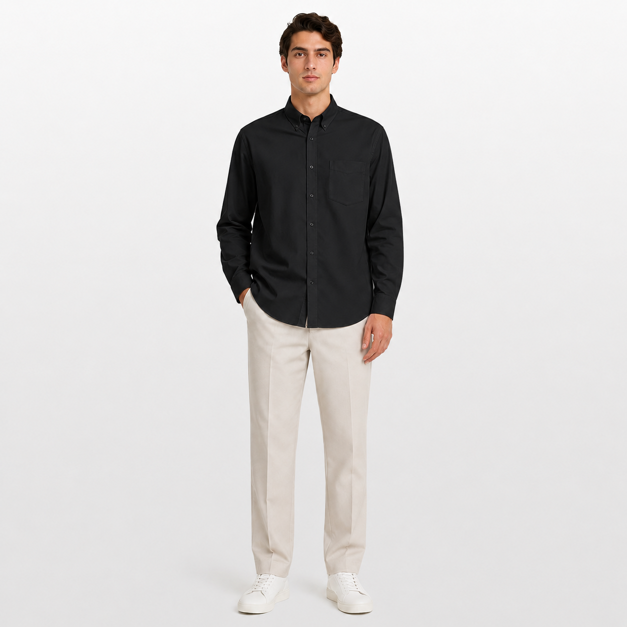Man wearing a black shirt and beige pants on a white background