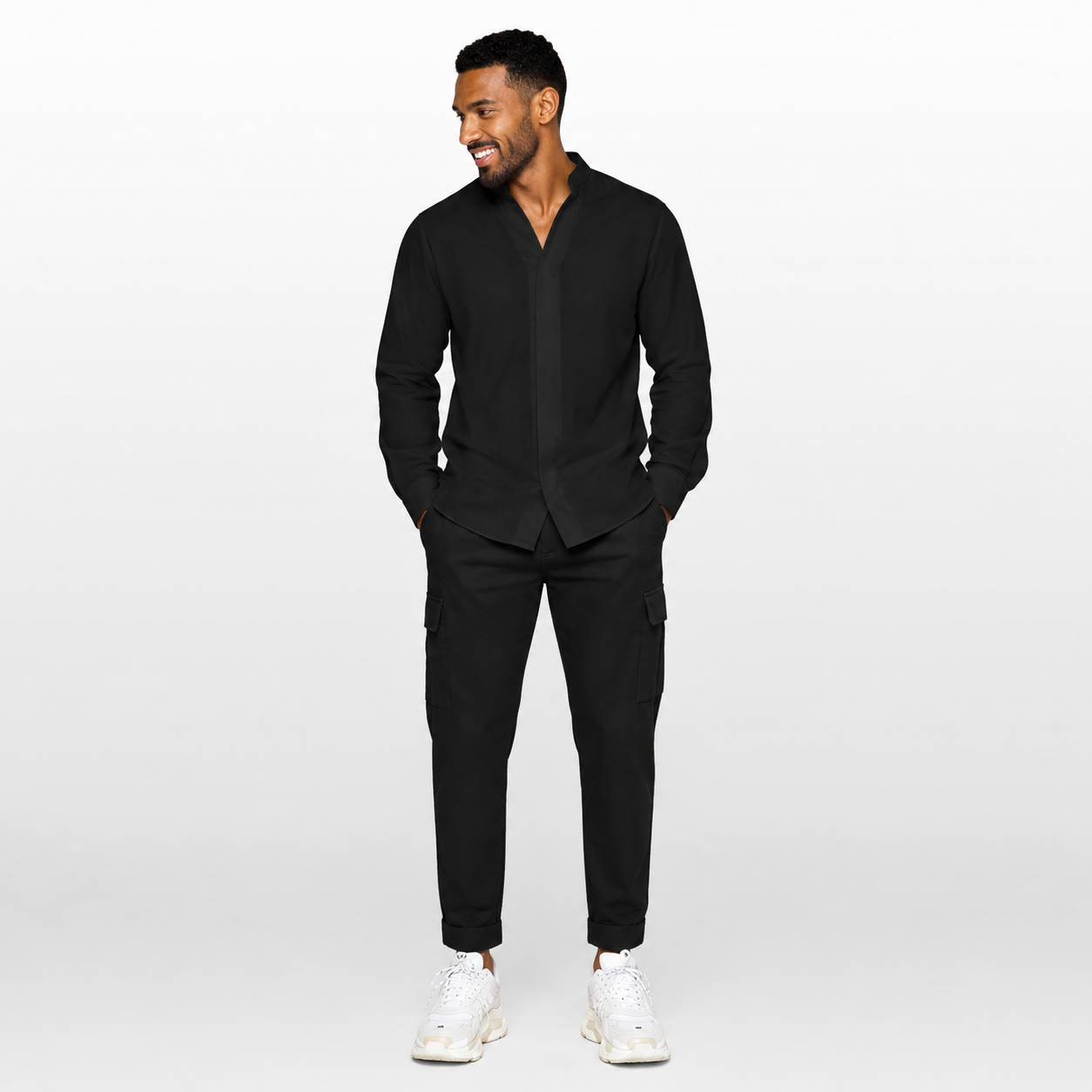 Man wearing a black suit with white sneakers on a white background