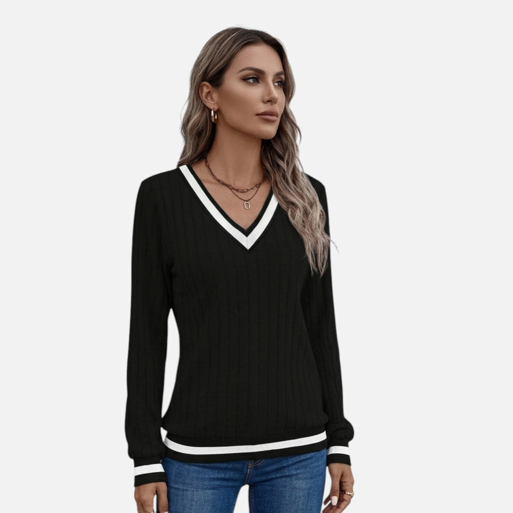 Woman wearing a black sweater with white trim on a white background