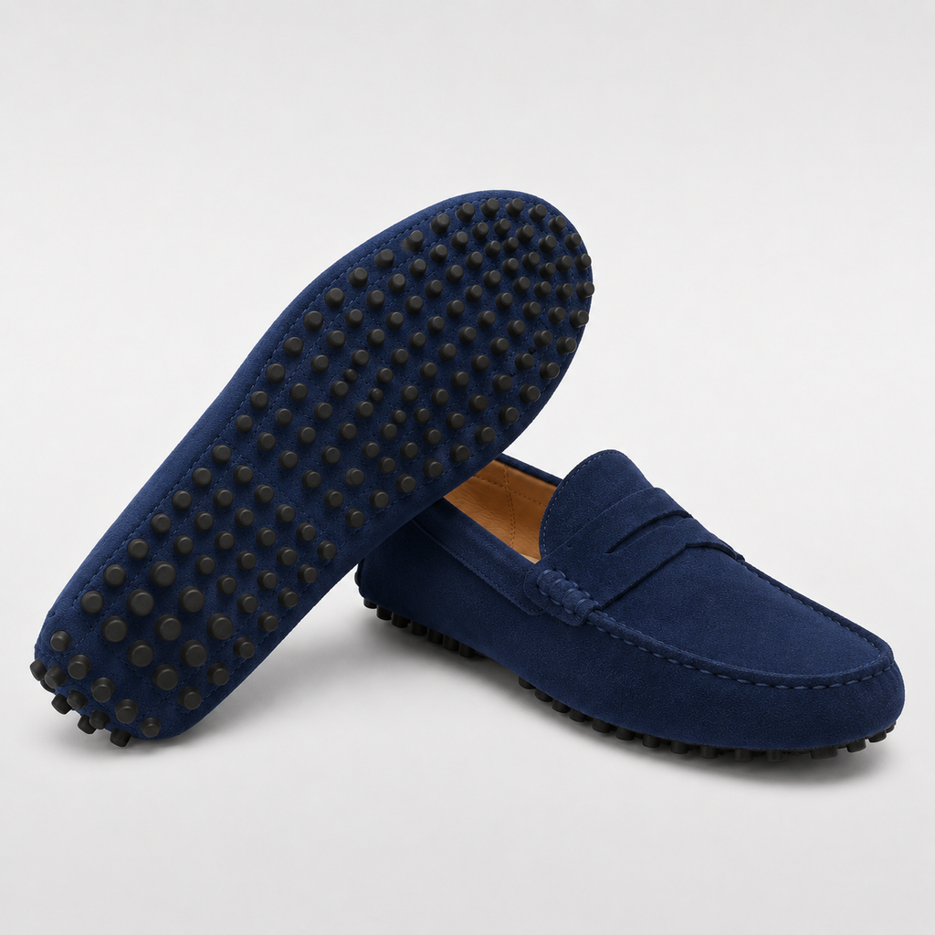 Pair of blue loafers with black soles on a light gray background