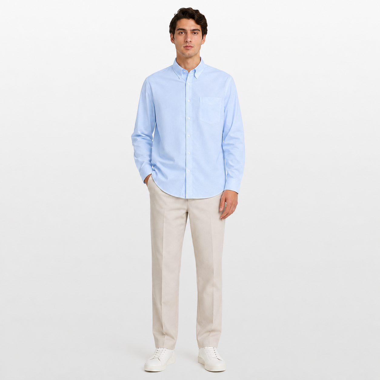 Man wearing a light blue shirt and beige pants on a white background