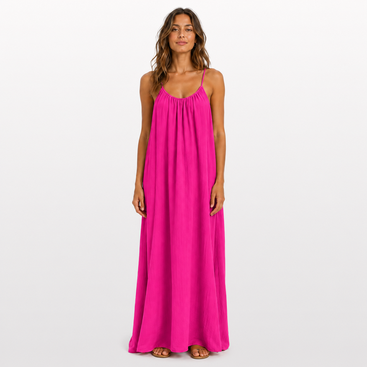 Woman wearing a bright pink maxi dress on a white background