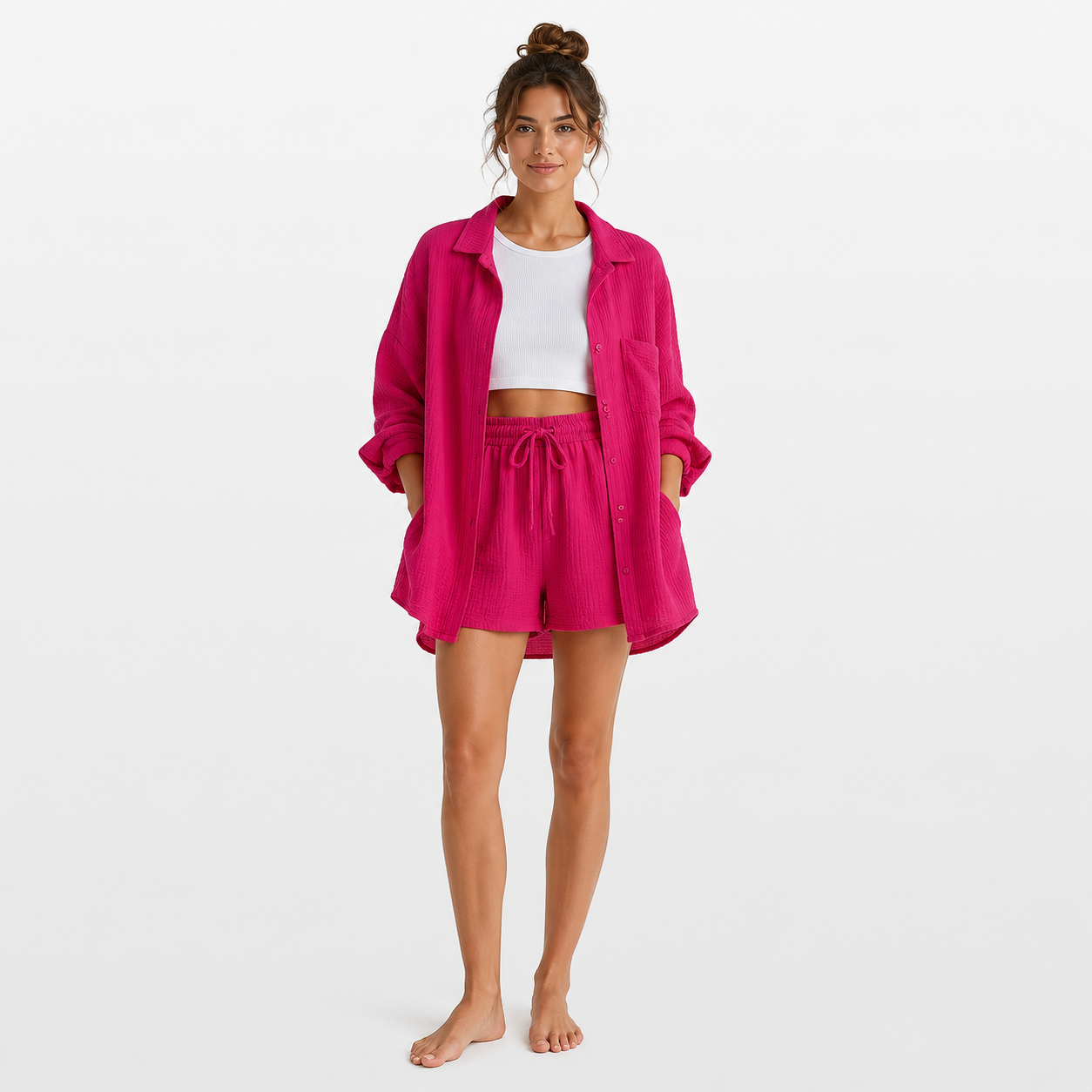 Woman wearing a bright pink outfit with a matching jacket and shorts on a white background
