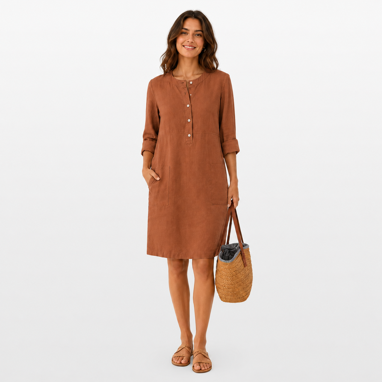 Woman wearing a brown dress holding a woven bag on a white background