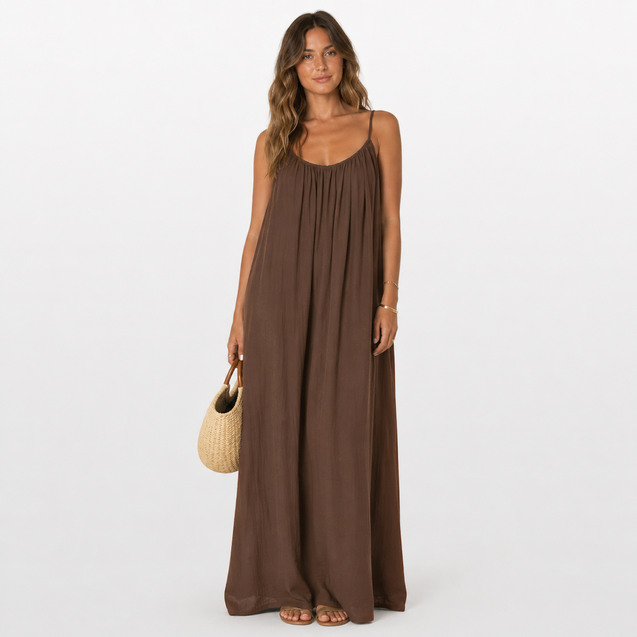 Woman wearing a brown dress holding a straw bag on a white background