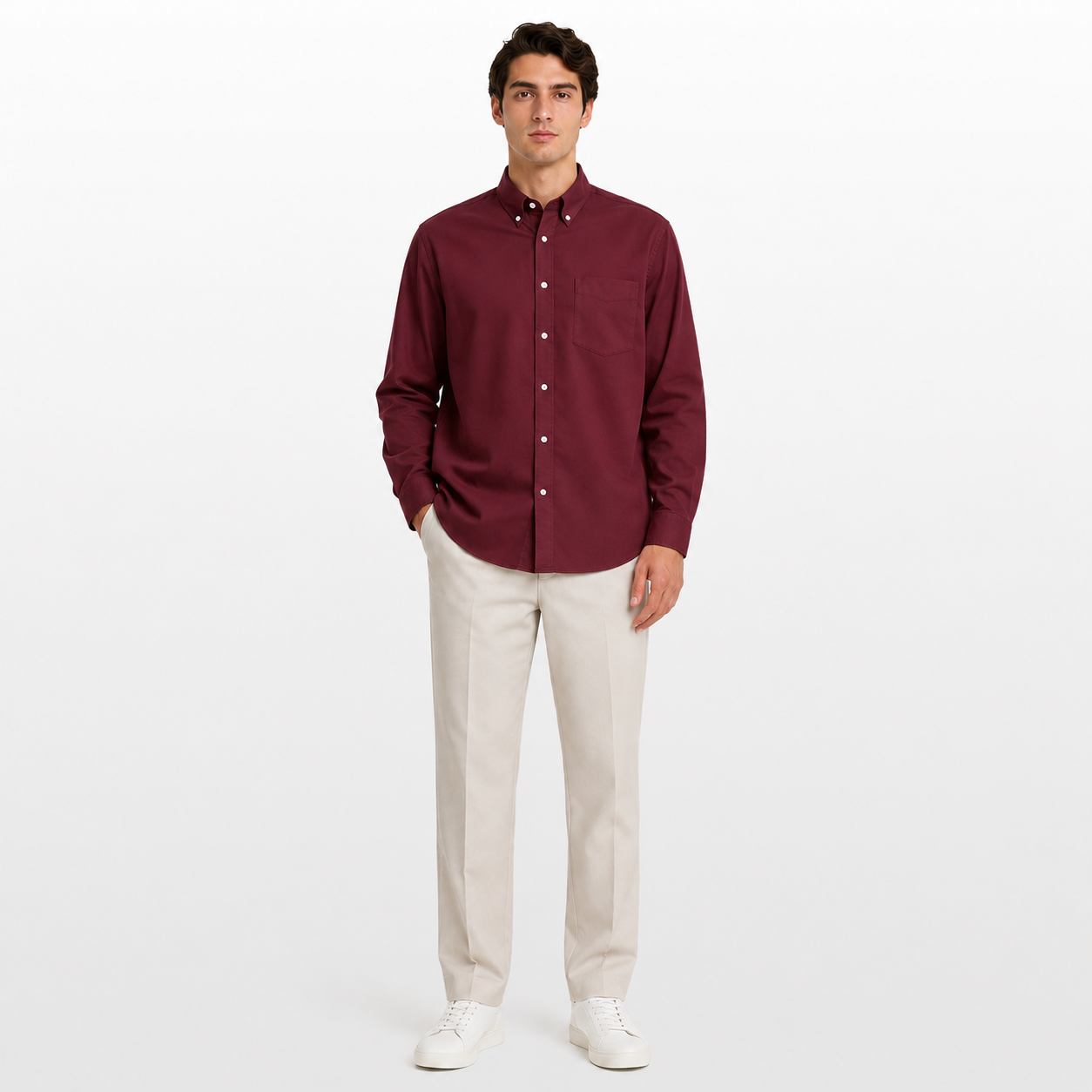 Man wearing a burgundy shirt and beige pants on a white background
