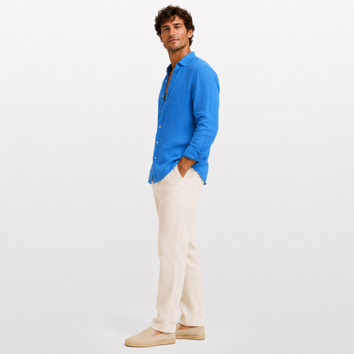 Man wearing a blue shirt and white pants on a light gray background