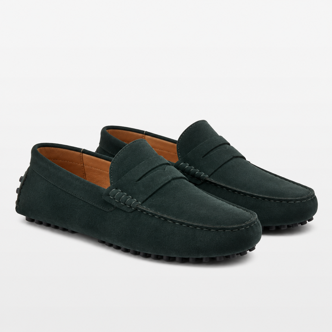 Pair of dark green loafers on a light gray background