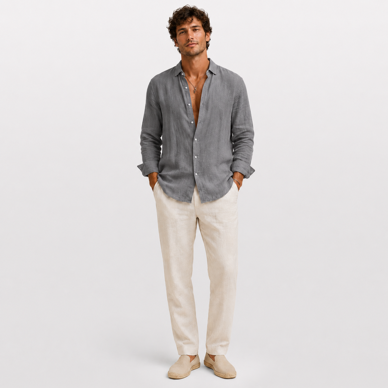 Man wearing a gray button-up shirt and beige pants on a white background