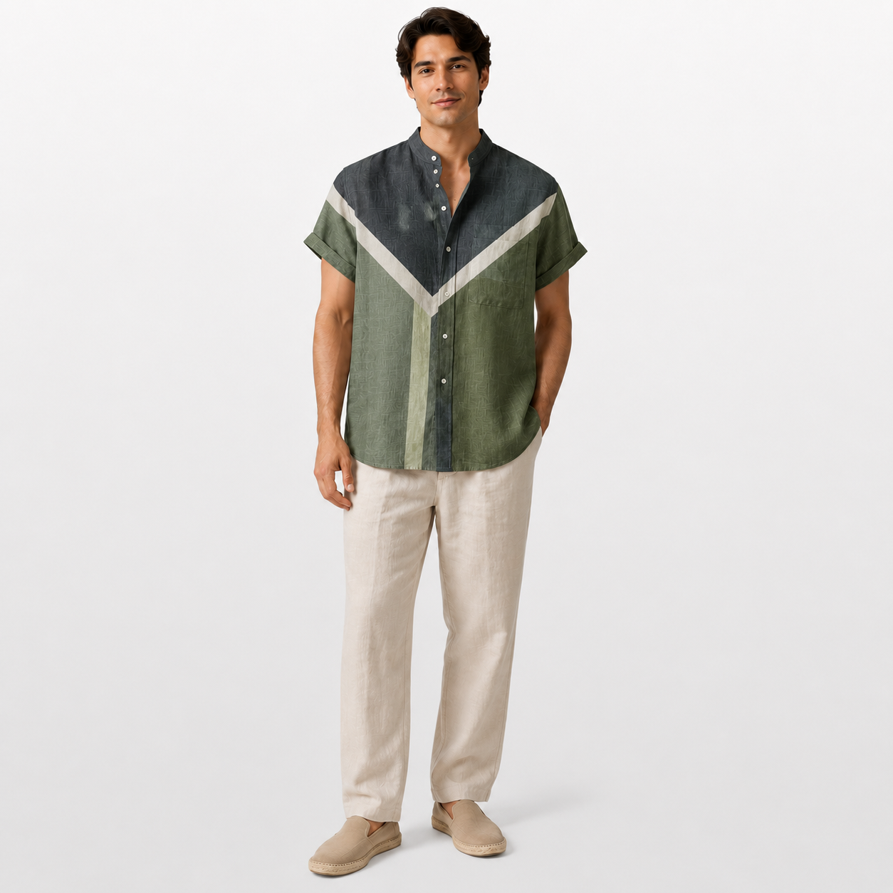Man wearing a green and gray patterned shirt with beige pants on a white background