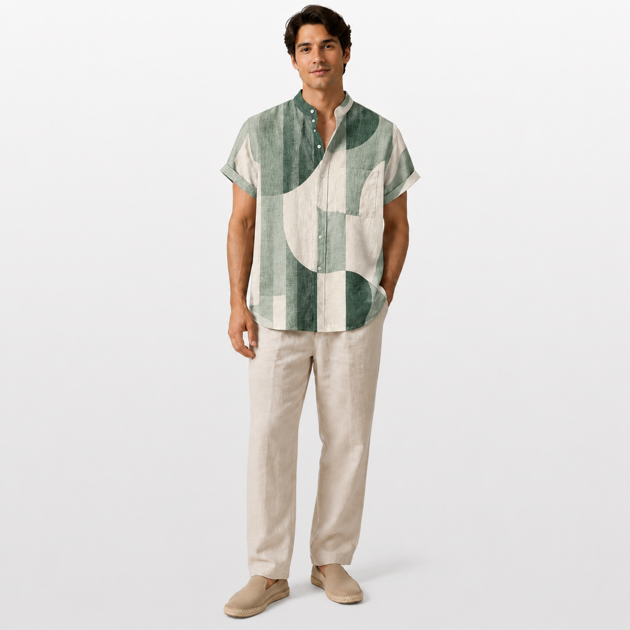Man wearing a green and white patterned shirt with beige pants on a white background