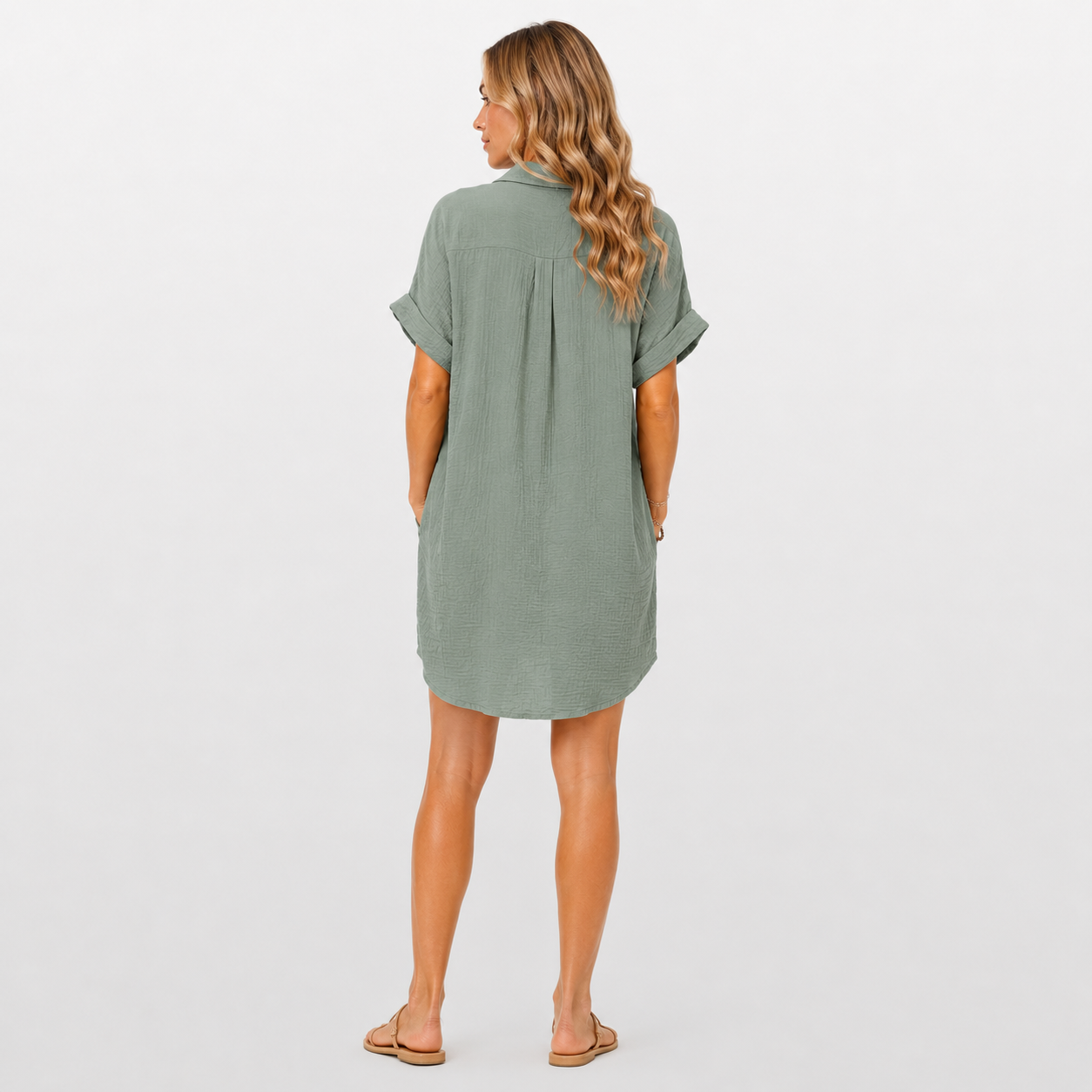 Woman wearing a green dress on a plain background