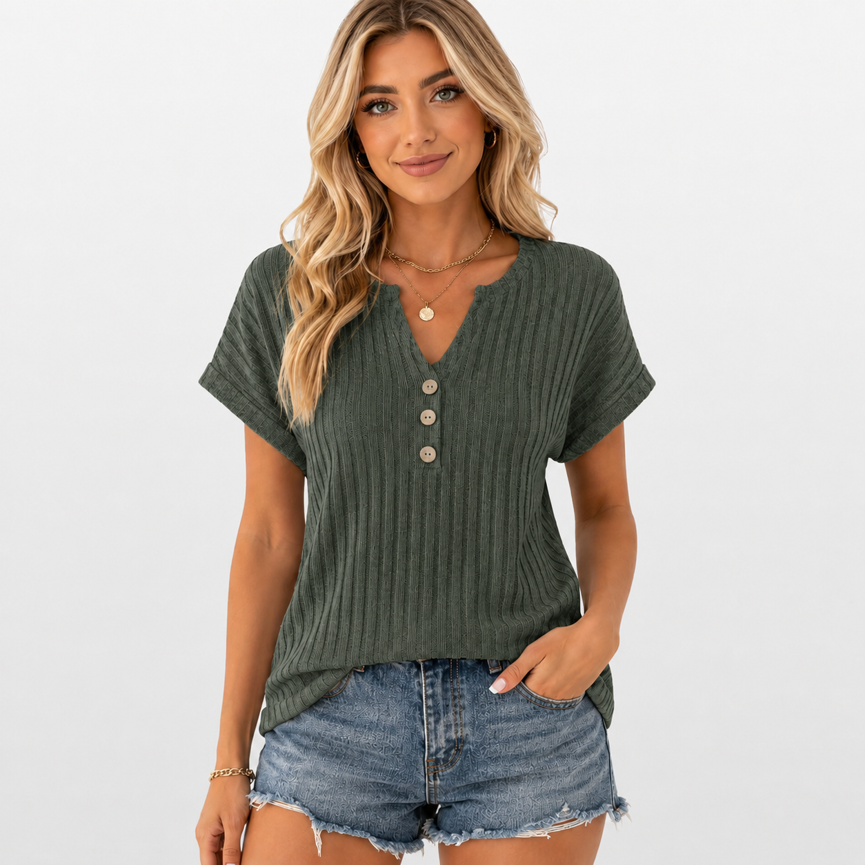 Woman wearing a green ribbed henley shirt and denim shorts on a white background