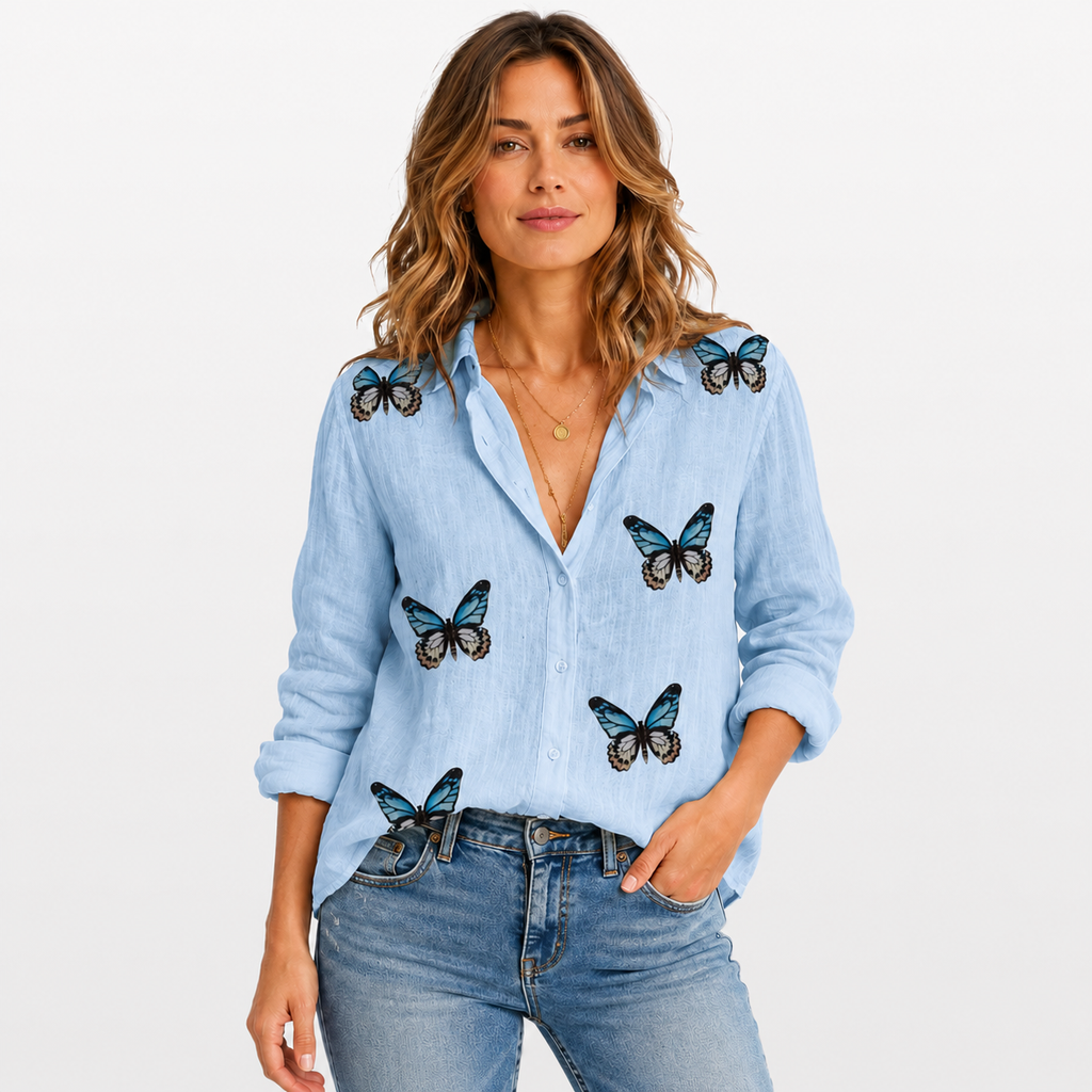 Woman wearing a light blue denim shirt with butterfly patterns on a white background