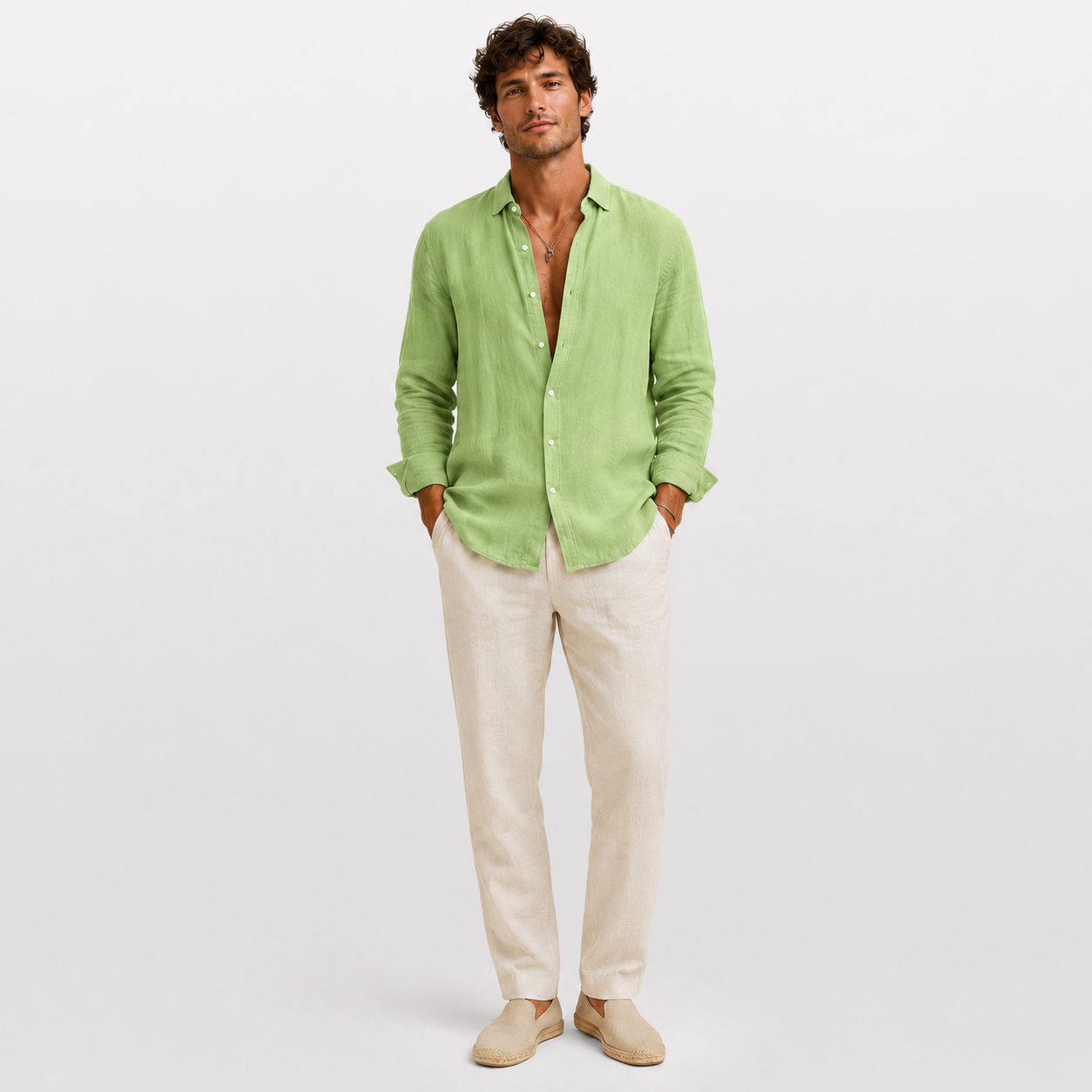 Man wearing a light green linen shirt and beige pants on a white background
