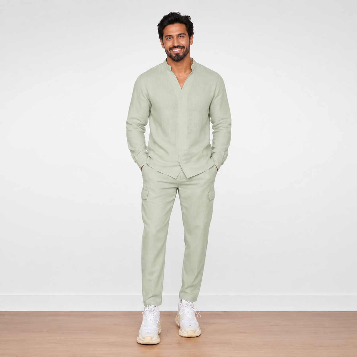 Man wearing a light green outfit with white sneakers on a plain background