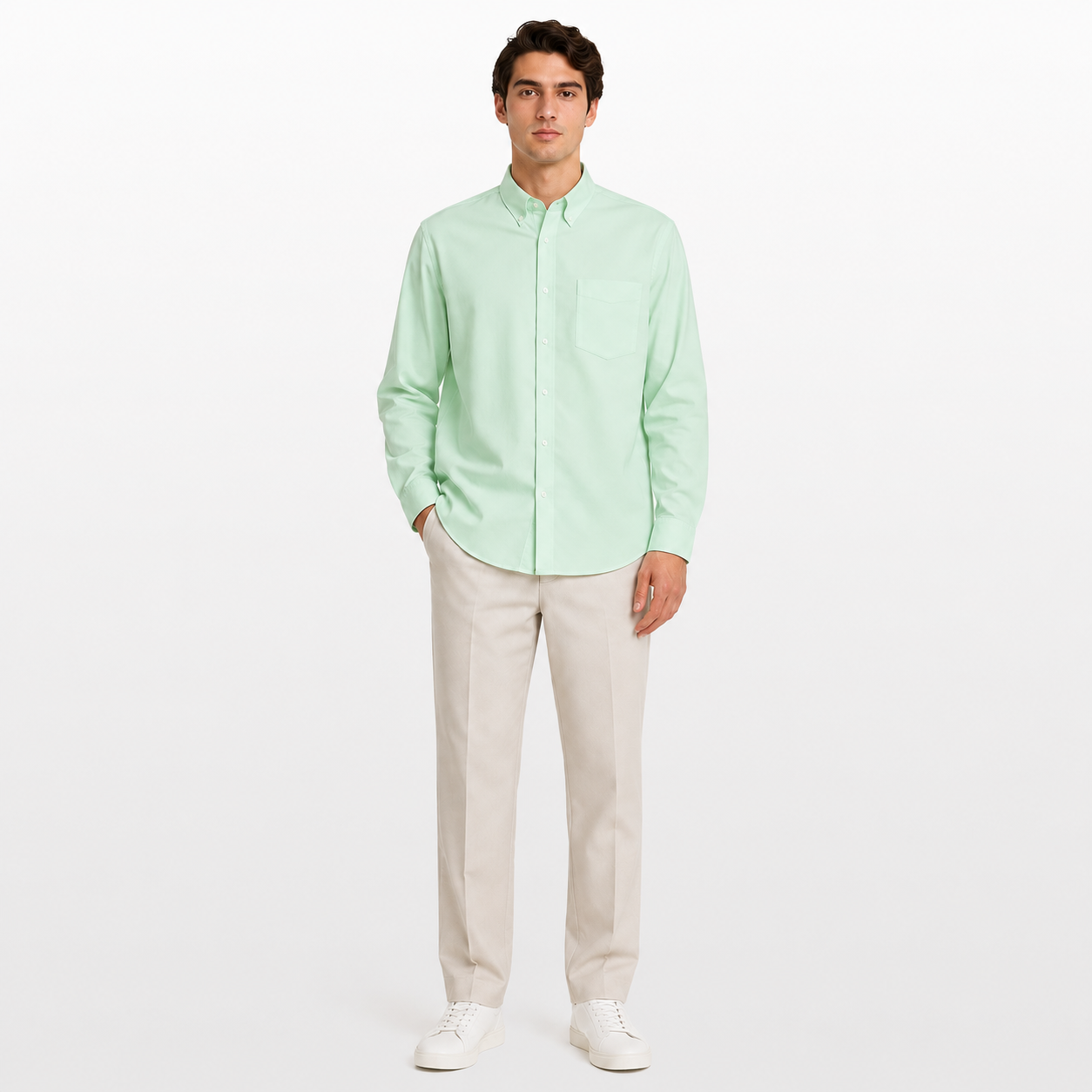 Man wearing a light green shirt and beige pants on a white background